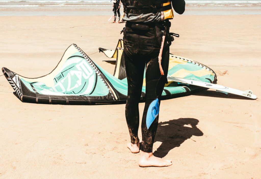 Kitesurfing instructor guiding a student through advanced tricks during a training session in Zanzibar. Group of kitesurfers performing advanced tricks on the waves under sunny Zanzibar weather.