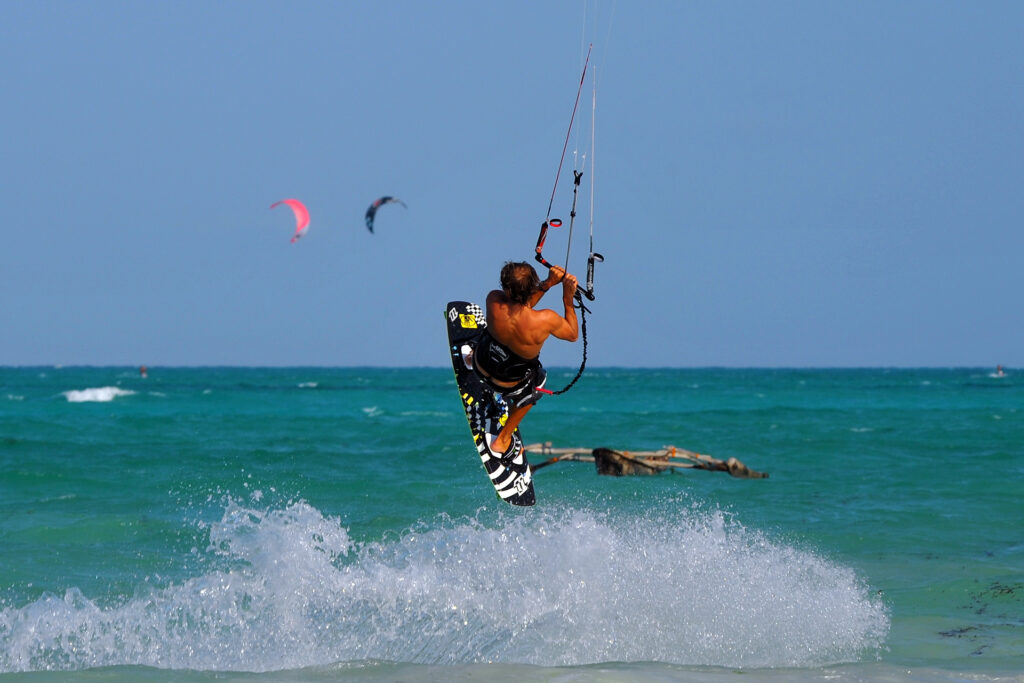 Kitesurfer practicing Handle Passes while rotating in mid-air, showcasing advanced kitesurfing skills.
Kitesurfer performing a Front Loop with a forward rotation on a windy day in Zanzibar.